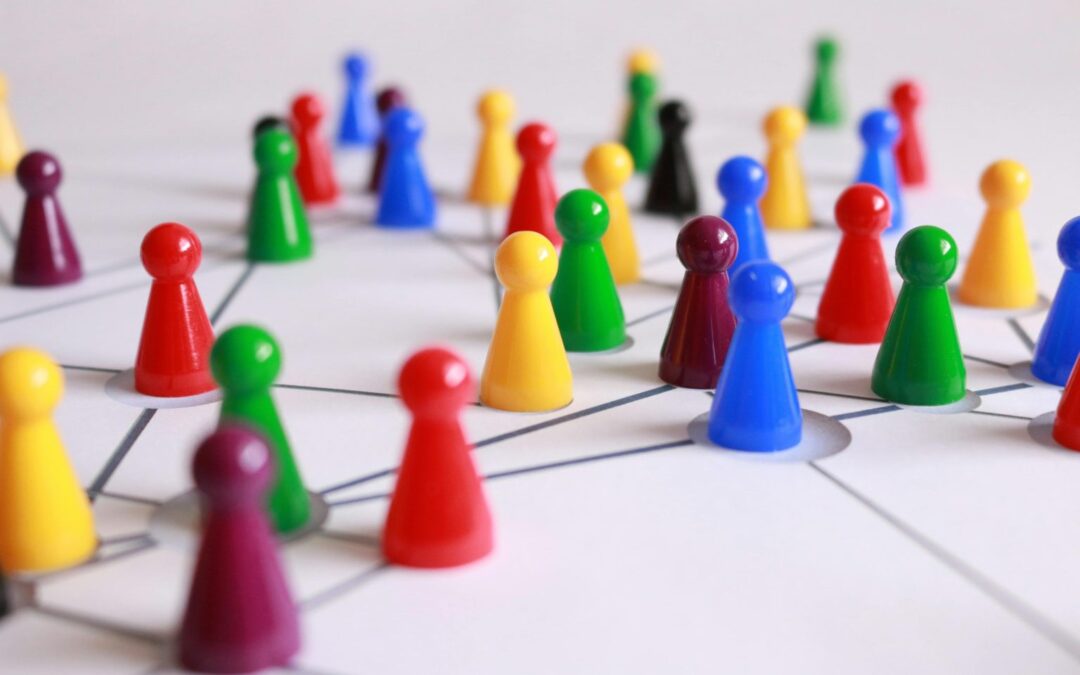 Muchas piezas de colores que representan a personas sobre un tablero con líneas conectoras